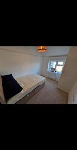 The Cosy House في ويلينغتون: غرفة نوم بها سرير ونافذة +3 صور