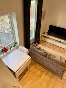 a living room with a couch and a tv at Röda Stugan in Örby, Älvsjö in Stockholm