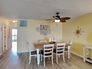 een eetkamer met een tafel en stoelen en een plafondventilator bij Winds V1 #3B - My Top Paradise in Carolina Beach +17 foto's
