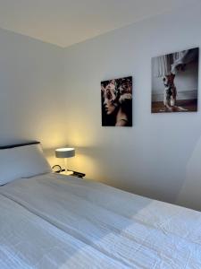 a bedroom with a bed with two pictures on the wall at Röda Stugan in Örby, Älvsjö in Stockholm