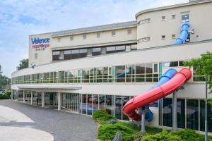 a red slide in front of a building at VR Spa Apartman in Velence +4 photos