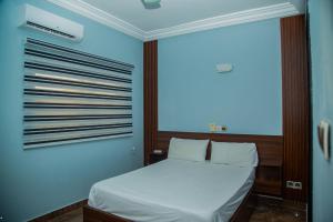 a bedroom with a white bed with a window at Sika Résidence Bénin in Cocotomey