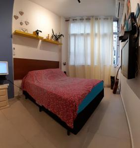 a bedroom with a bed and a television in it at Angel's House Flamengo RJ in Rio de Janeiro