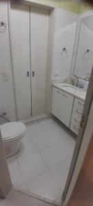 a white bathroom with a toilet and a sink at Angel's House Flamengo RJ in Rio de Janeiro