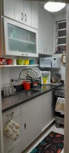 a kitchen with white cabinets and a sink at Angel's House Flamengo RJ in Rio de Janeiro