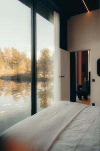 a bedroom with a bed and a large window at Īves, Koka Maja in Amatciems