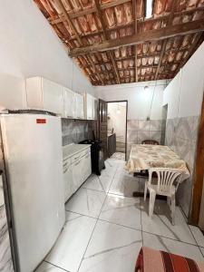 a kitchen with a table and a refrigerator in it at Casa em Itacaré no Centro, ao lado da Pituba in Itacaré