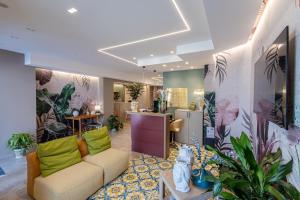 Una sala de estar con un sofá y algunas plantas. en Hotel Vento del Sud, en San Vito lo Capo