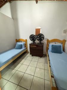 a room with two beds and a dresser with at Casa em Itacaré no Centro, ao lado da Pituba in Itacaré