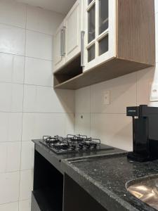 a kitchen with a stove and a counter top at Apartamento vizinho ao Shopping Manaira próx à Praia in João Pessoa