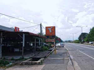 a building with a sign on the side of a road at T Hotel Changlun in Changlun