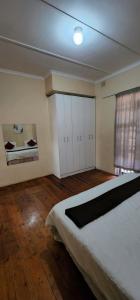 a bedroom with a large bed and a window at 18 Laburnum Lodge in Durban