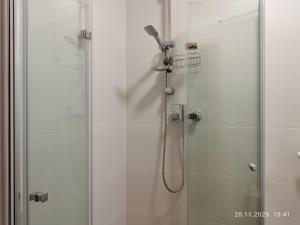 a shower with a glass door with a shower head at Apartament Pod Gwiazdami in Czarny Dunajec +29 photos