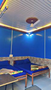 a blue room with a couch and a table at Kaafirana Adventure Camps and Cottages in Shivpuri