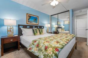 a bedroom with a large bed and a nightstand with a bed sidx sidx sidx at Kahana Reef 120 by Coldwell Banker Island Vacations in Kahana +51 photos