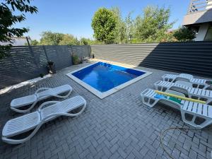 a patio with lounge chairs and a swimming pool at Casablanca Residence B in Cârcea