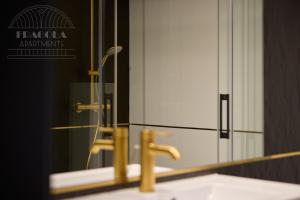 uno specchio da bagno con lavandino e rubinetto di Art Palace - Fragola Apartments a Cracovia Altre 10 foto