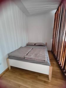 a bed in a white room with two windows at Cozy Studio-Self check in in Beograd