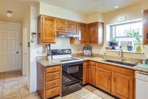 a kitchen with wooden cabinets and a stove top oven at 4 Mi to Dtwn The Crash Site Roswell Home! in Roswell