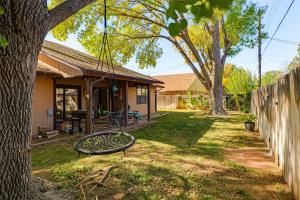 a yard with a swing in front of a house at 4 Mi to Dtwn The Crash Site Roswell Home! in Roswell