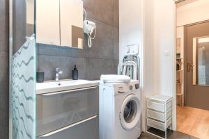 Un baño con lavadora y lavabo. en Saphir d'Aix Studio, en Aix-les-Bains