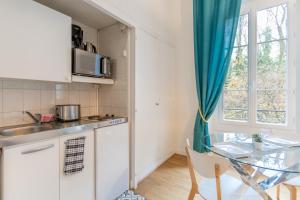 Una pequeña cocina con una mesa y una ventana. en Saphir d'Aix Studio, en Aix-les-Bains