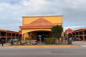 马塔莫罗斯Hotel Mirage Express的街道上有一栋黄色瓦顶建筑