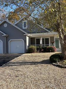 a grey house with a tree and a driveway at Spacious Home Bethany Beach in Frankford