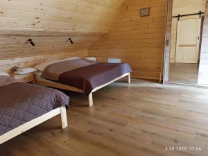 a room with two beds in a wooden cabin at Apartament Pod Gwiazdami in Czarny Dunajec