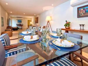 a dining room with a glass table with food on it at NOVO Mansão Pé na Areia com Heliponto, 1 Piscina, 1 Hidro, Sauna e 5 Quartos in Angra dos Reis