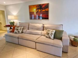 a couch in a living room with a painting on the wall at NOVO Mansão Pé na Areia com Heliponto, 1 Piscina, 1 Hidro, Sauna e 5 Quartos in Angra dos Reis +106 photos