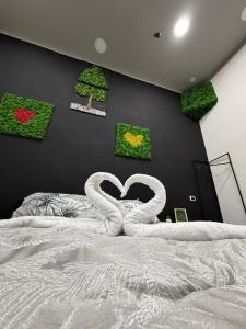 ein Schlafzimmer mit einem Bett, bei dem zwei Schwäne ein Herz bilden. in der Unterkunft Balbi Soft Room in Caserta