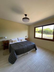 a bedroom with a bed and a large window at La Madriguera de Potrerillo in Alta Gracia