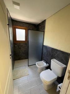 a bathroom with a toilet and a sink at La Madriguera de Potrerillo in Alta Gracia +16 photos