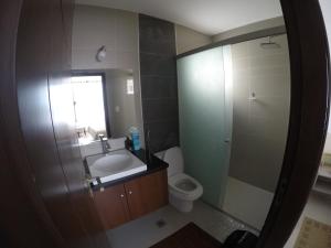 ein Badezimmer mit Waschbecken, Toilette und Spiegel in der Unterkunft Serenity Palmas- in Santa Cruz de la Sierra