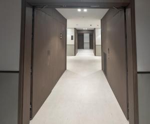 an empty corridor of an office building with brown doors at GRANDE SIGNATURE with a direct Burj Khalifa view and Private Fountain Show at 62nd floor with DXB AIRPORT VIP Shuttle option for 6 guests in Dubai +102 photos