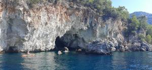 un groupe de personnes en kayak devant une grotte dans l'établissement Dalyan Boat Tours, à Ortaca