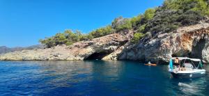 un bateau en face d'une grotte dans l'eau dans l'établissement Dalyan Boat Tours, à Ortaca