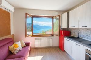 a kitchen with a red couch and a large window at Eden Garden in Fonteno