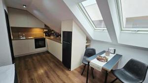 a kitchen and dining room with a table and chairs at RG Apartments in Šamorín