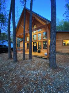 une cabane dans les bois avec des arbres dans l'établissement The Stunning Shady Creek Cabin, à Broken Bow