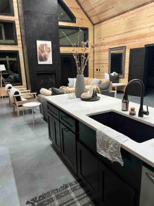 un grand salon avec une cuisine et un canapé dans l'établissement The Stunning Shady Creek Cabin, à Broken Bow