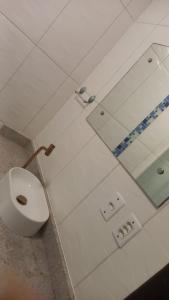 une salle de bain avec des toilettes blanches et un miroir dans l'établissement Suíte Ampla Ideal para Família, à Garopaba