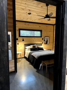 une chambre avec un lit dans un mur en bois dans l'établissement The Stunning Shady Creek Cabin, à Broken Bow