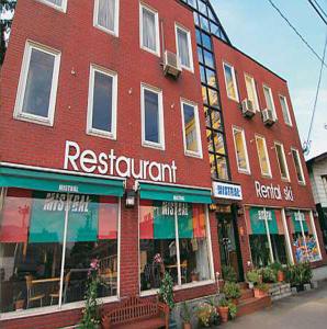 ein rotes Backsteingebäude mit einem Restaurant auf einer Straße in der Unterkunft Mistral in Minami Uonuma