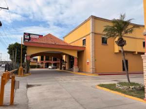 un gran edificio amarillo con garaje en Hotel Mirage Express, en Matamoros