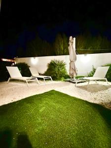 zwei Stühle und ein Regenschirm auf einer Terrasse nachts in der Unterkunft Boutique Higueron Spa in Fuengirola