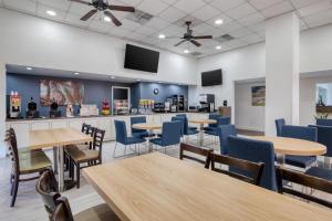 a dining room with tables and chairs and televisions at Best Western Of Walterboro in Walterboro