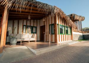 a pavilion with a couch and a straw roof at Aranwa Vichayito Beach Resort in Vichayito
