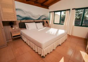 a bedroom with a large bed in a room with windows at Aranwa Vichayito Beach Resort in Vichayito